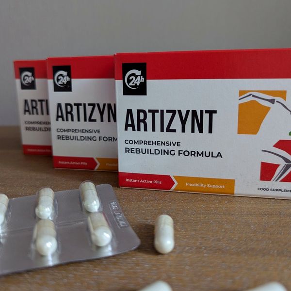 Tres cajas de ArtiZynt, blancas con franjas rojas, en fila sobre madera y un blíster de cápsulas delante