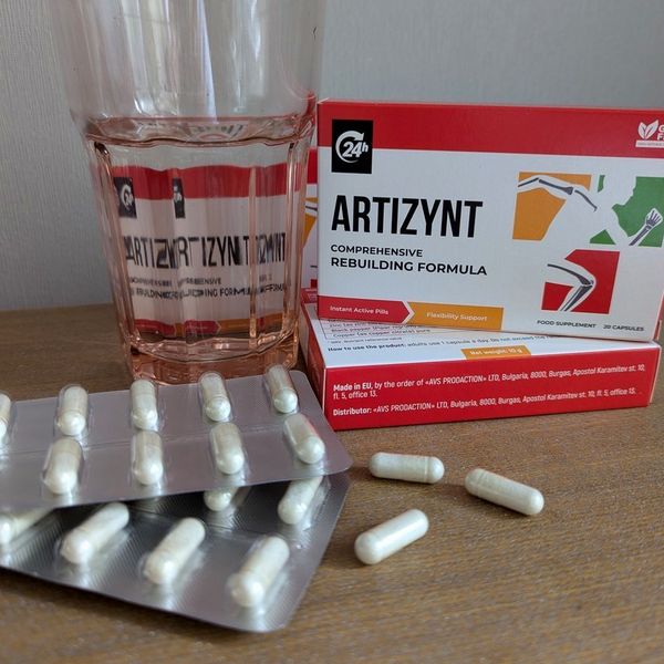 Caja de ArtiZynt junto a un vaso de agua y blísteres de cápsulas blancas