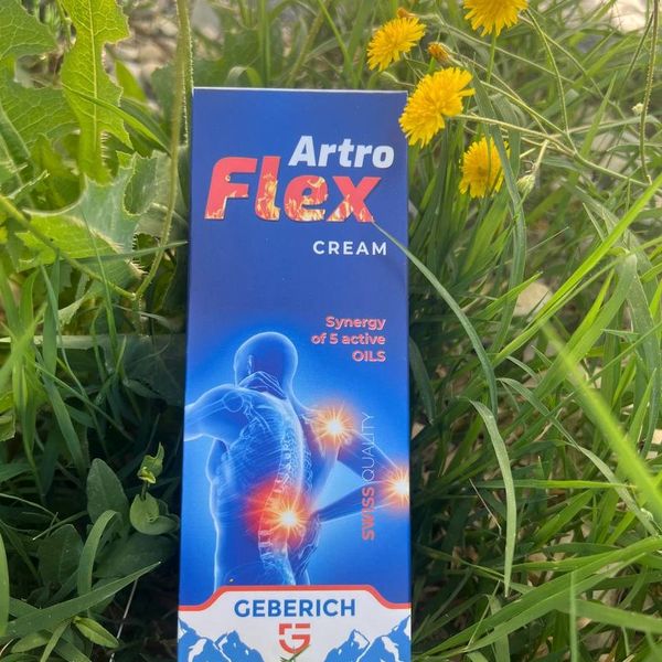 Caja azul de ArtroFlex Cream sobre la hierba, con flores amarillas