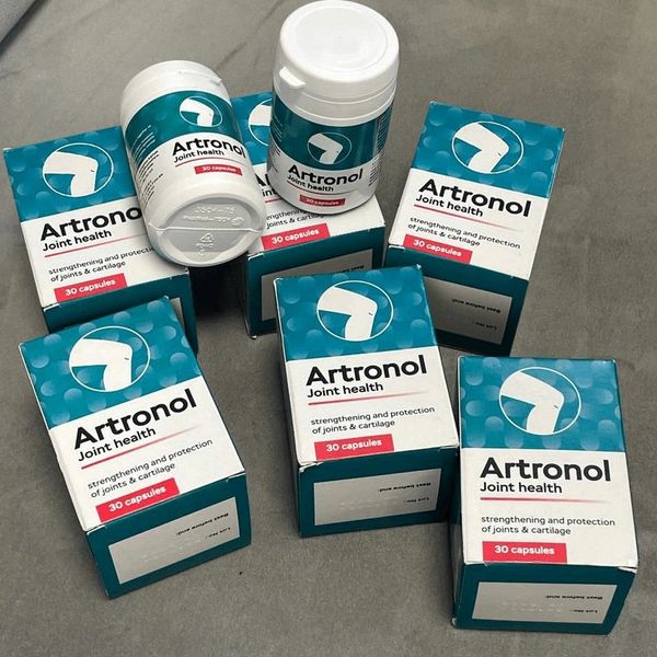 Seis cajas verde azulado y blancas de Artronol y dos botes blancos de 30 cápsulas, vistos desde arriba