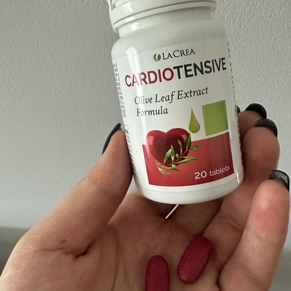 Mano que sostiene el bote de Cardiotensive de 20 comprimidos