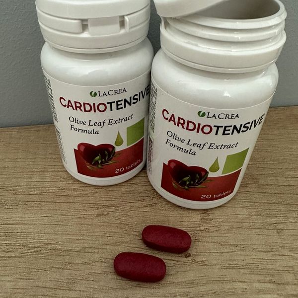 Dos botes de Cardiotensive y dos comprimidos rojos sobre una mesa