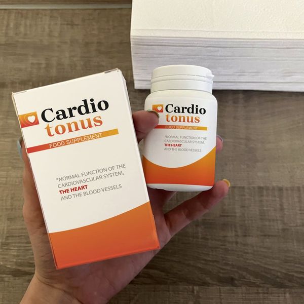 Mano que sostiene la caja de Cardiotonus con el bote detrás