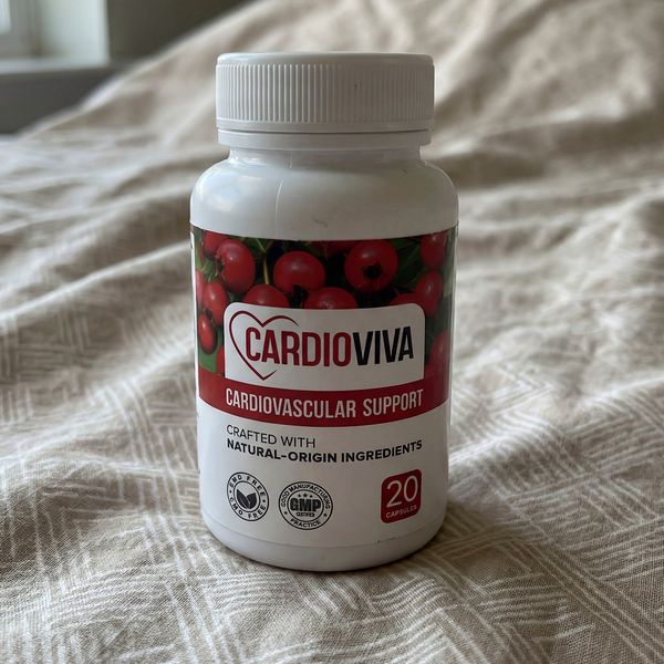 Bote blanco de CardioViva sobre una colcha clara