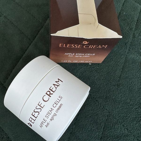 Tarro blanco de Elesse Cream tumbado junto a su caja granate