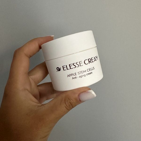 Mano que sostiene el tarro blanco de Elesse Cream