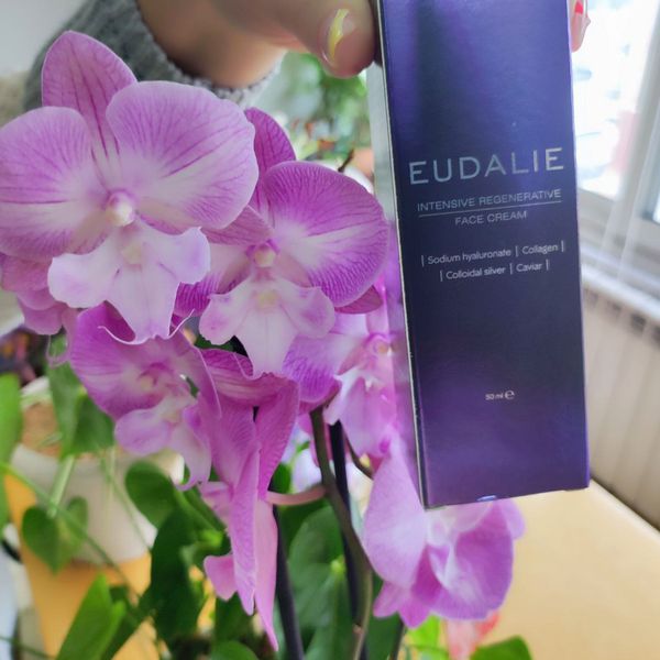 Caja violeta de Eudalie junto a una orquídea
