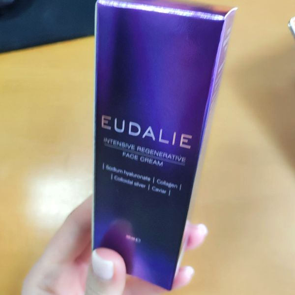 Mano que sostiene la caja violeta de Eudalie