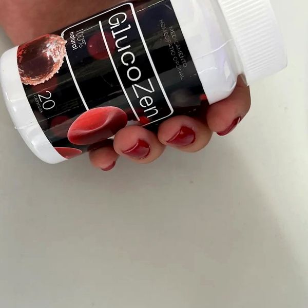 Mano que sostiene el bote de GlucoZen tumbado, con el 20 de la etiqueta a la vista
