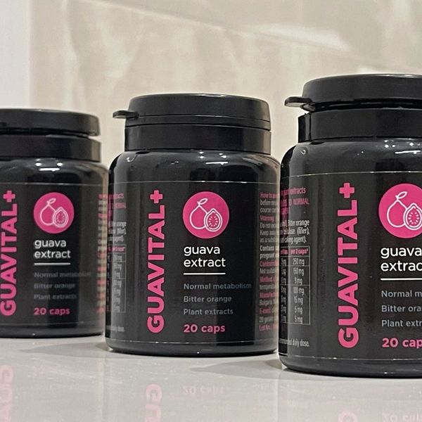 Tres botes negros de Guavital+ con letras fucsia, «guava extract, 20 caps», alineados sobre una mesa blanca