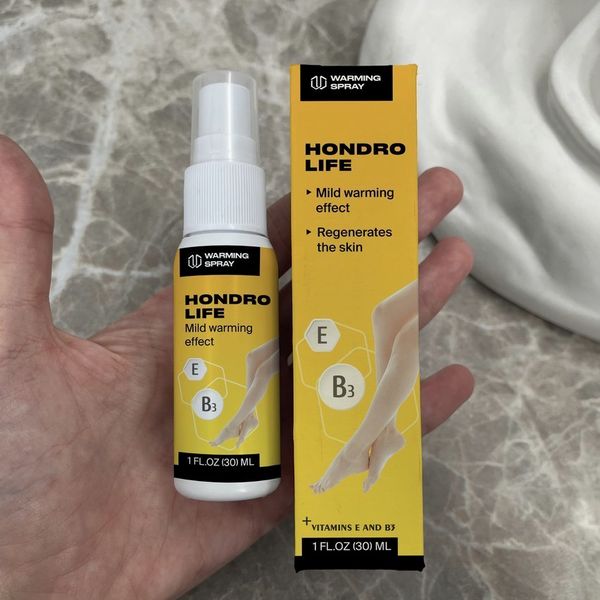 Mano que sostiene el espray de Hondrolife junto a su caja