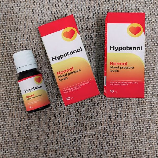 Frasco de Hypotenol tumbado junto a dos cajas sobre una tela gris
