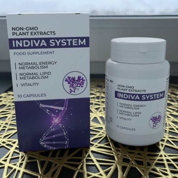 Caja y bote de Indiva System de 10 cápsulas sobre un salvamanteles dorado