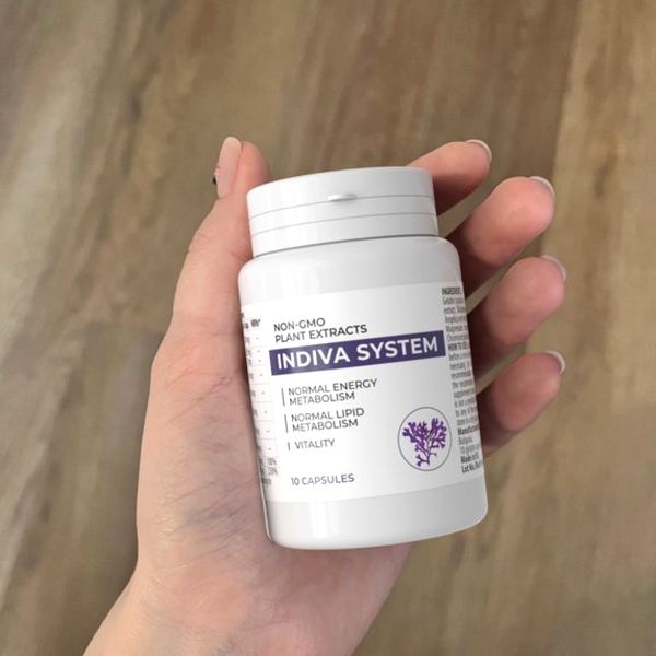 Mano que sostiene el bote blanco de Indiva System