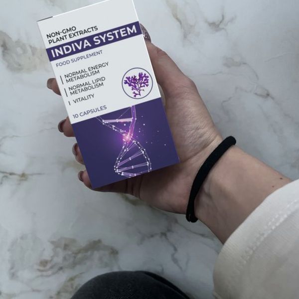 Mano que sostiene la caja blanca y morada de Indiva System