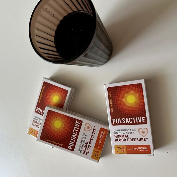 Tres cajas de Pulsactive junto a un vaso de café