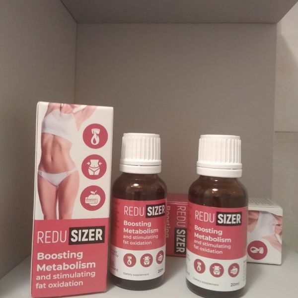Dos frascos cuentagotas ámbar de Redusizer, con etiqueta roja, junto a su caja blanca y roja en una balda