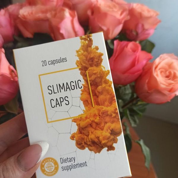 Mano que sostiene la caja de Slimagic Caps delante de unas rosas
