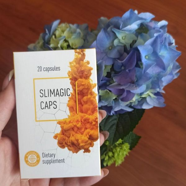 Mano que sostiene la caja de Slimagic Caps junto a unas hortensias