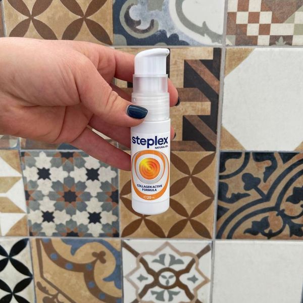 Mano que sostiene el frasco de Steplex sobre un suelo de baldosas