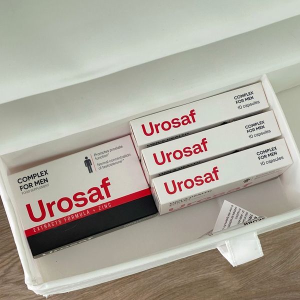 Cuatro cajas de Urosaf, blancas, rojas y negras, en un organizador blanco: una de frente y tres de canto