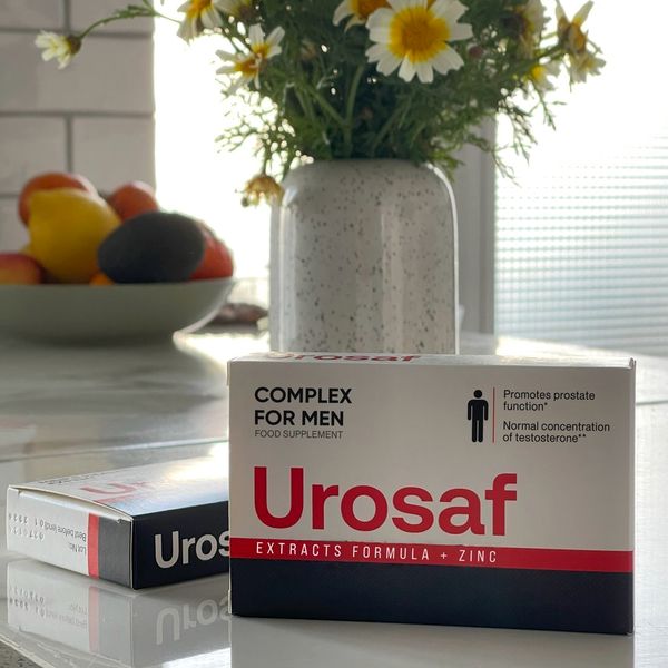 Caja blanca y roja de Urosaf delante de un jarrón con flores