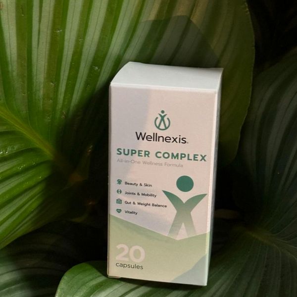 Caja blanca y verde de Wellnexis entre hojas de una planta